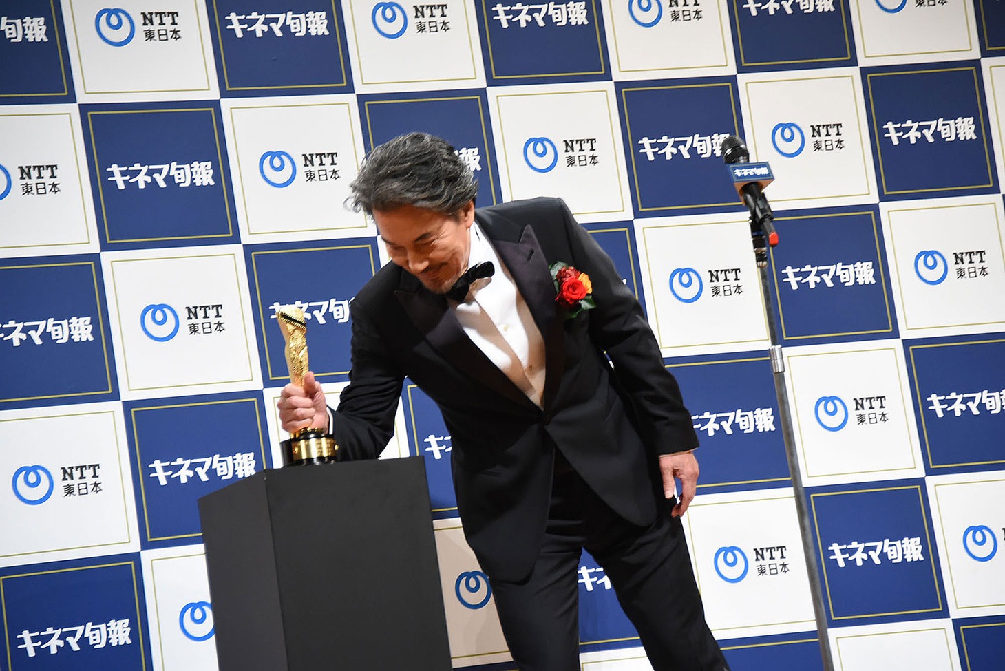 トロフィーを手に取る役所広司。
