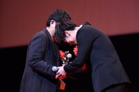 握手をする大友啓史（左）、佐藤健（右）。