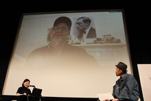 マイク・ミルズ（スクリーン）と大島依提亜（右）。