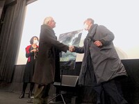 握手するレオス・カラックス（左）と古舘寛治（右）。