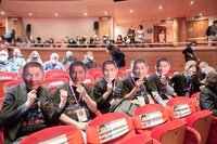 北野武のお面を手にするファンたち。