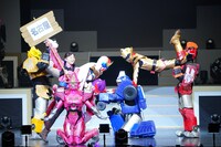 ポーズを決めるゼンカイジャー、ツーカイザー、ステイシーザーと、「名古屋」と書かれた札を持って走り回るフリント・ゴールドツイカー。