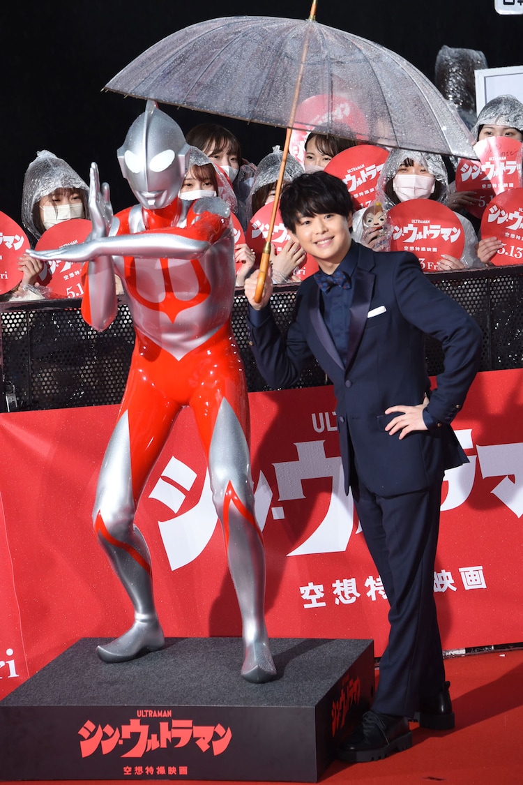 ウルトラマン（左）と傘に入りポーズを決める有岡大貴（右）。