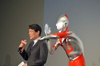 塚越隆行（左）と、ウルトラマンの立像。