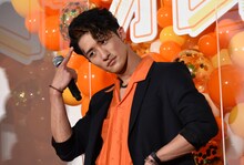 髪に入れたオレンジのワンポイントカラーをアピールする岩本照。