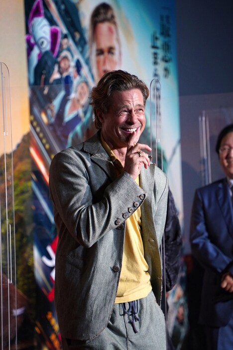 投げたマイクが思わぬ音を出したので自ら「シー」のジェスチャーをするブラッド・ピット。