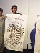さかなクンが描いたイラストを手にする磯村勇斗。