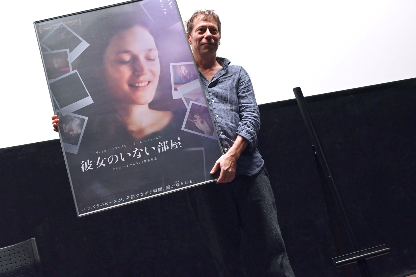 作品パネルを自ら持ち上げてアピールするマチュー・アマルリック。