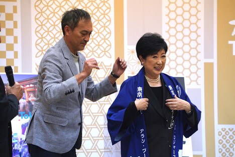 小池百合子（右）に法被を羽織らせる渡辺謙（左）。