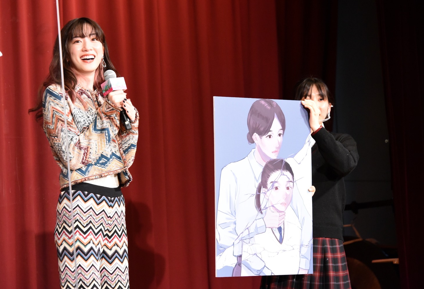 学生が描いた「母性」のポスターを見て笑顔を浮かべる永野芽郁（左）。