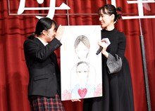 学生が描いた「母性」のポスターを受け取る戸田恵梨香（右）。