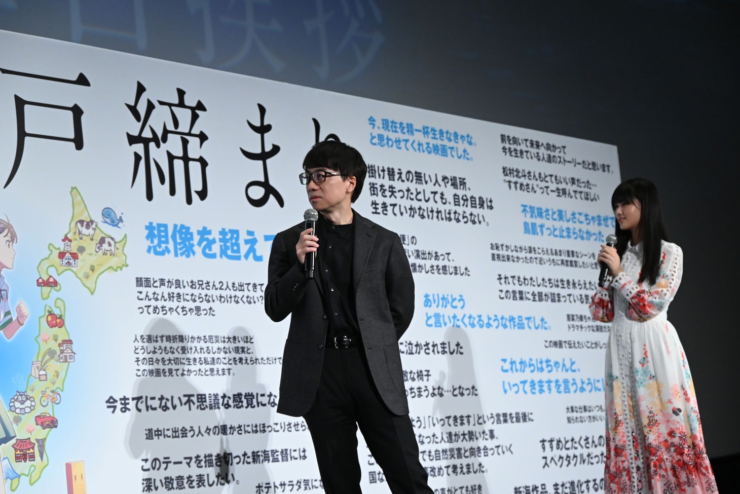 感想コメントを眺める新海誠（左）、原菜乃華（右）。