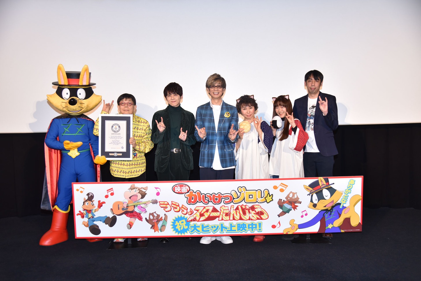 「映画かいけつゾロリ ラララ♪スターたんじょう」公開記念舞台挨拶にて、左からゾロリ、原ゆたか、梶裕貴、山寺宏一、愛河里花子、くまいもとこ、緒方隆秀。