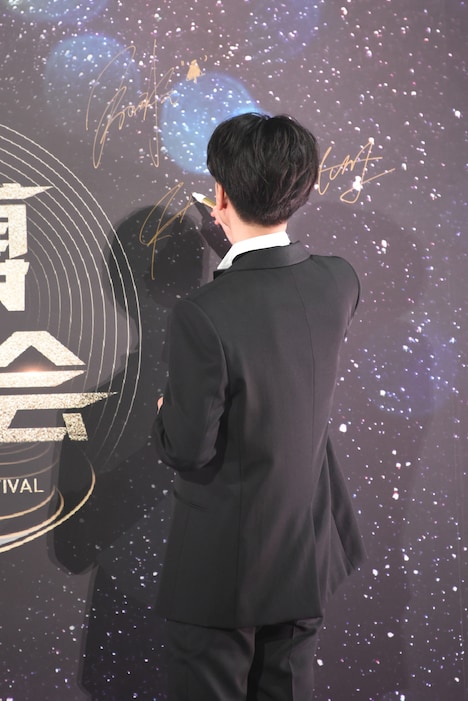 サインを書く佐藤健。