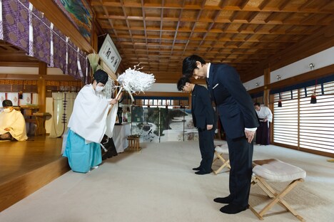 祈祷を受ける竹野内豊、田中亮。