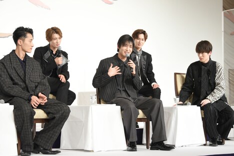 手話で思いを伝える目黒蓮（前列中央）を見守るSnow Manメンバー。カメラのレンズが多く向けられたのを察した向井康二（後列左）は、映り込みを狙って体を寄せていた。