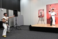 パフォーマンスを応援するヌンチャク伝道師・願羽マサル（左）。