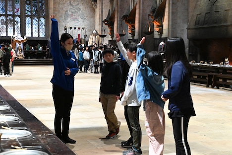 ホグワーツ魔法魔術学校の大広間を見学する小学生たち。