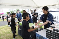 子供たちにサプライズで弁当を配る松本潤（手前右）。