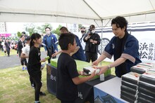 子供たちにサプライズで弁当を配る松本潤（手前右）。