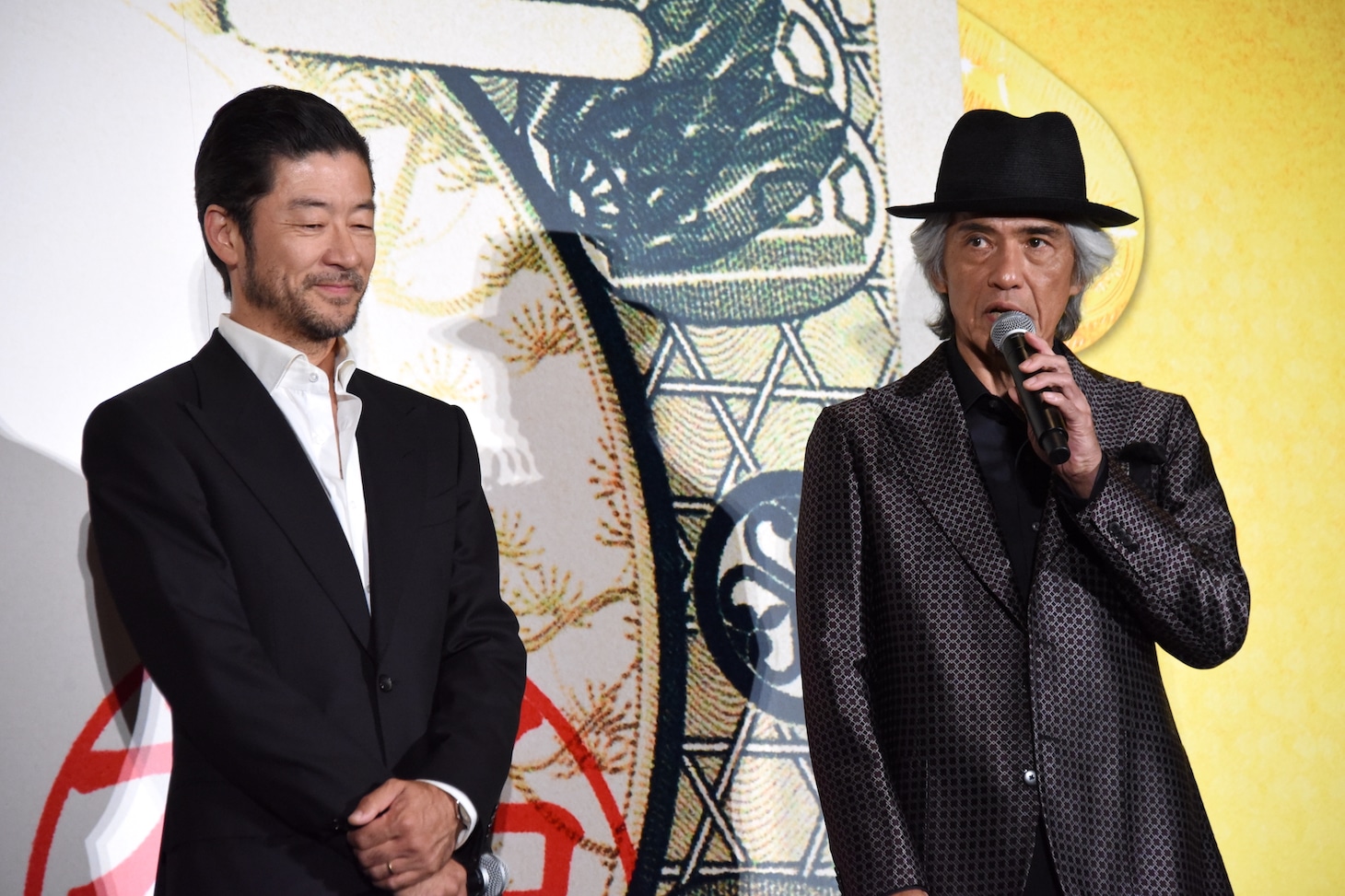 左から浅野忠信、佐藤浩市。