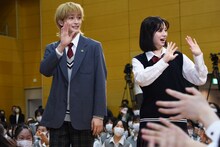 生徒に手を振りながら登場する高橋文哉（左）と桜田ひより（右）。