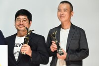 上海国際映画祭のトロフィーを手に持つ熊切和嘉（左）、フォトセッションに参加した室井孝介（右）。