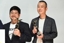 上海国際映画祭のトロフィーを手に持つ熊切和嘉（左）、フォトセッションに参加した室井孝介（右）。