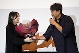誕生日を迎える行平あい佳(左)にサプライズで花束を渡した青柳翔(右)。