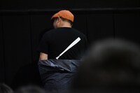 バットがプリントされた映画オリジナルTシャツを見せる白石晃士。