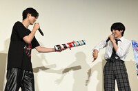 バトンを渡す簡秀吉（左）と本島純政（右）。