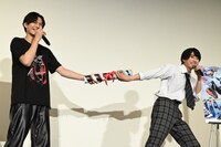 バトンを渡す簡秀吉（左）と本島純政（右）。