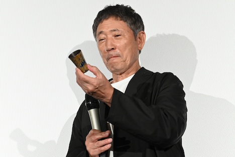 プレゼントされたおちょこを眺める小林薫。