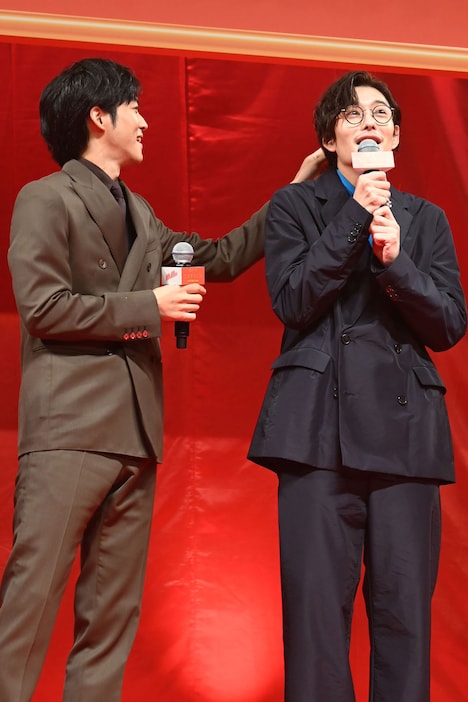 岡田将生（右）の髪に付いた紙片を取ってあげる松坂桃李（左）。