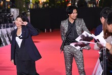 フランクに観客に話しかける青木崇高（右）と、遠くの報道陣に向かってポーズを取る安藤サクラ（左）。