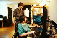 談笑しながら映像を観る山崎貴（奥）と白組スタッフ（手前）。