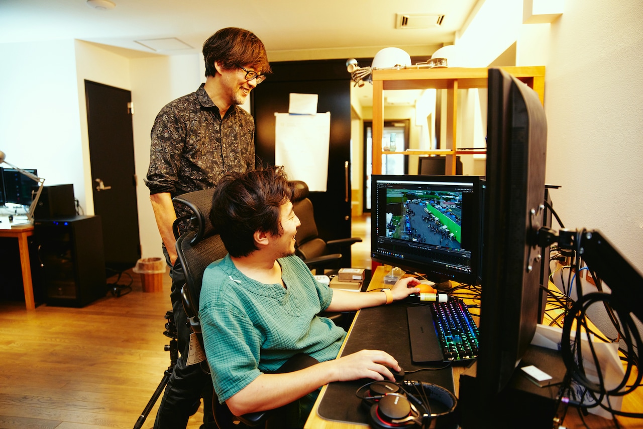 談笑しながら映像を観る山崎貴（奥）と白組スタッフ（手前）。