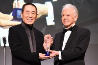 左からチャン・イーモウ、安藤裕康。