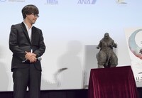 山崎貴（左）と、撮影に使われたゴジラの立像（右）。