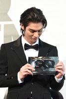 受け取ったばかりのトロフィーを見つめるBright。