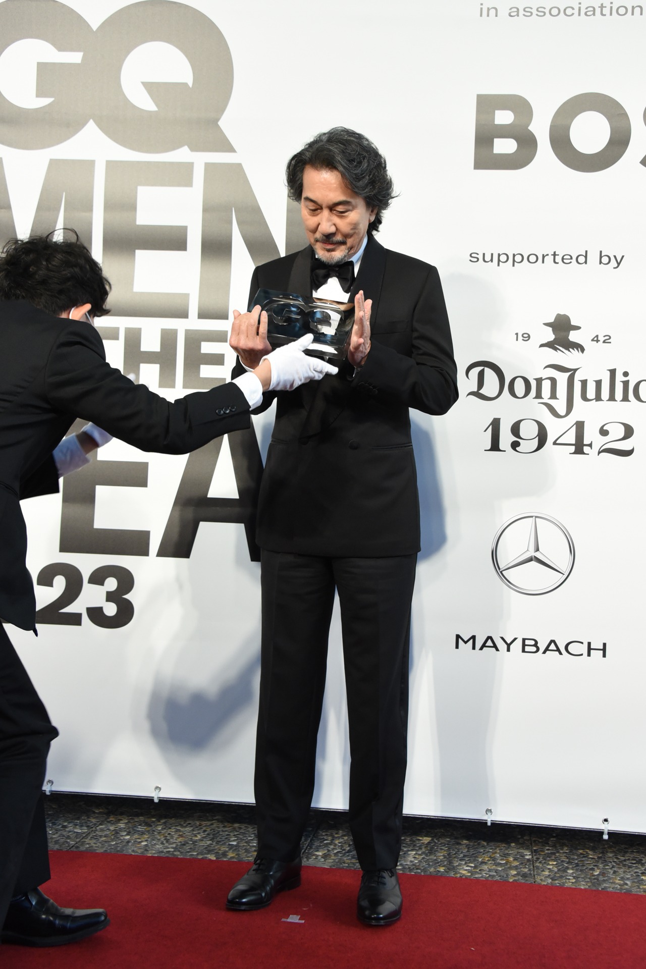 トロフィーをそっと受け取る役所広司。