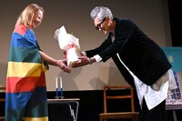 アルマ・ポウスティ（左）に花束を渡す松重豊（右）。