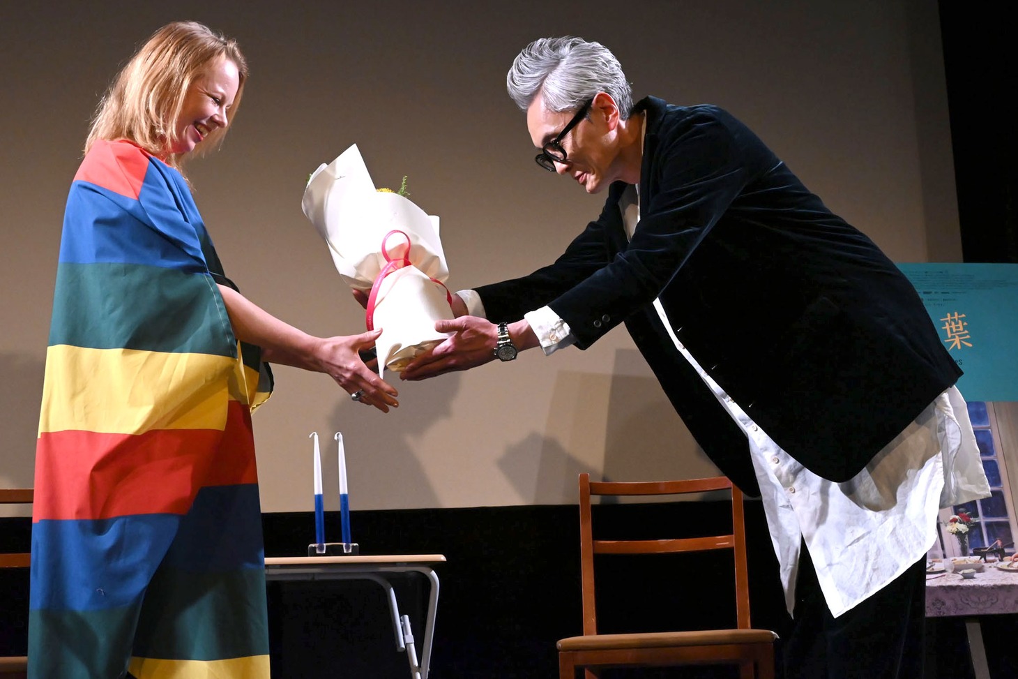 アルマ・ポウスティ（左）に花束を渡す松重豊（右）。