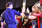 ソーのコスプレイヤーとハイタッチをするトム・ヒドルストン（左）。
