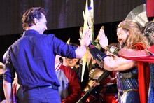 ソーのコスプレイヤーとハイタッチをするトム・ヒドルストン（左）。