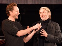 マッツ・ミケルセン（右）のマイクを持ってあげるトム・ヒドルストン（左）。