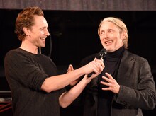 マッツ・ミケルセン（右）のマイクを持ってあげるトム・ヒドルストン（左）。