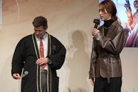 池崎理人（右）の話を聞きながら、半纏にマイクをしまうザック・スナイダー（左）。