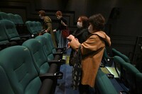 座席に刺繍された映画人の名前を写真に撮る客。