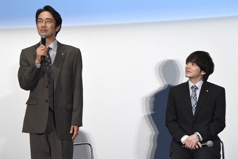 「固い固い」と言われながら挨拶をする眞島秀和（左）を見守る林遣都（右）。